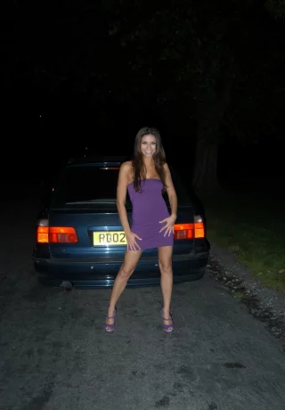 Длинноногая британская цыпочка выставляет свои сиськи напоказ на капоте автомобиля ночью - 1