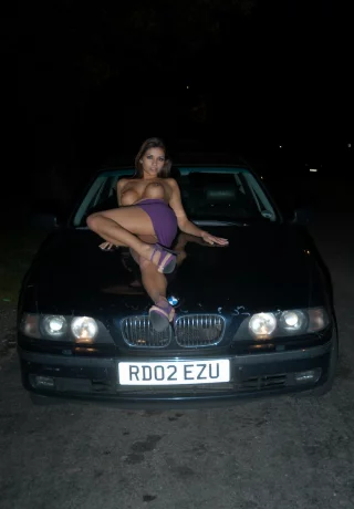 Длинноногая британская цыпочка выставляет свои сиськи напоказ на капоте автомобиля ночью - 10